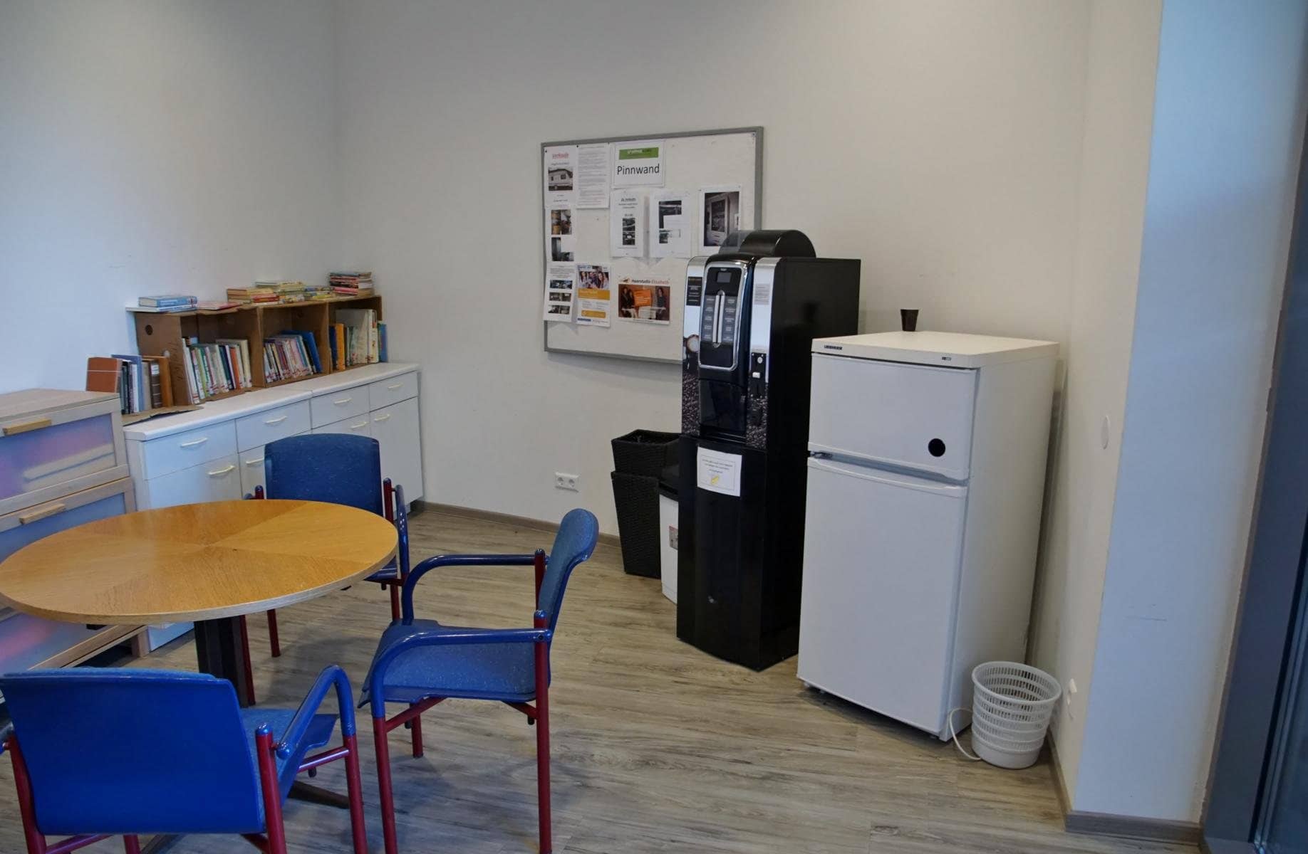 Aufenthaltsraum mit Tisch, Sesseln, Kaffeeautomat und Kühlschrank