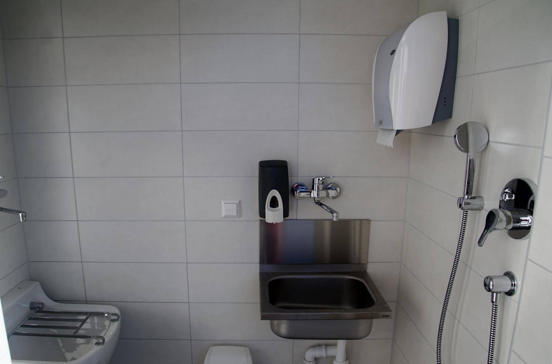 Gefliester Raum mit Ausgussbecken, Edelstahlspüle und Handbrause