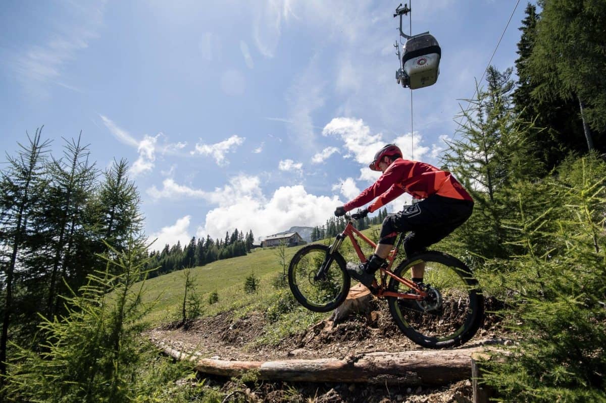 Mountainbiker im Bikepark unter einer Seilbahn