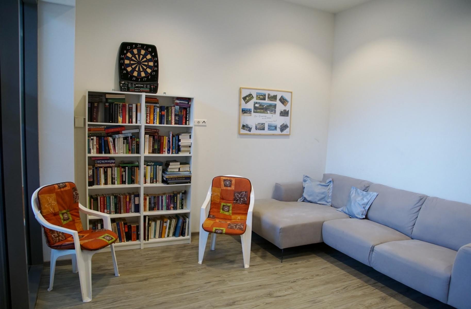 Leseecke mit Bücherregal, Sofa und Dartscheibe