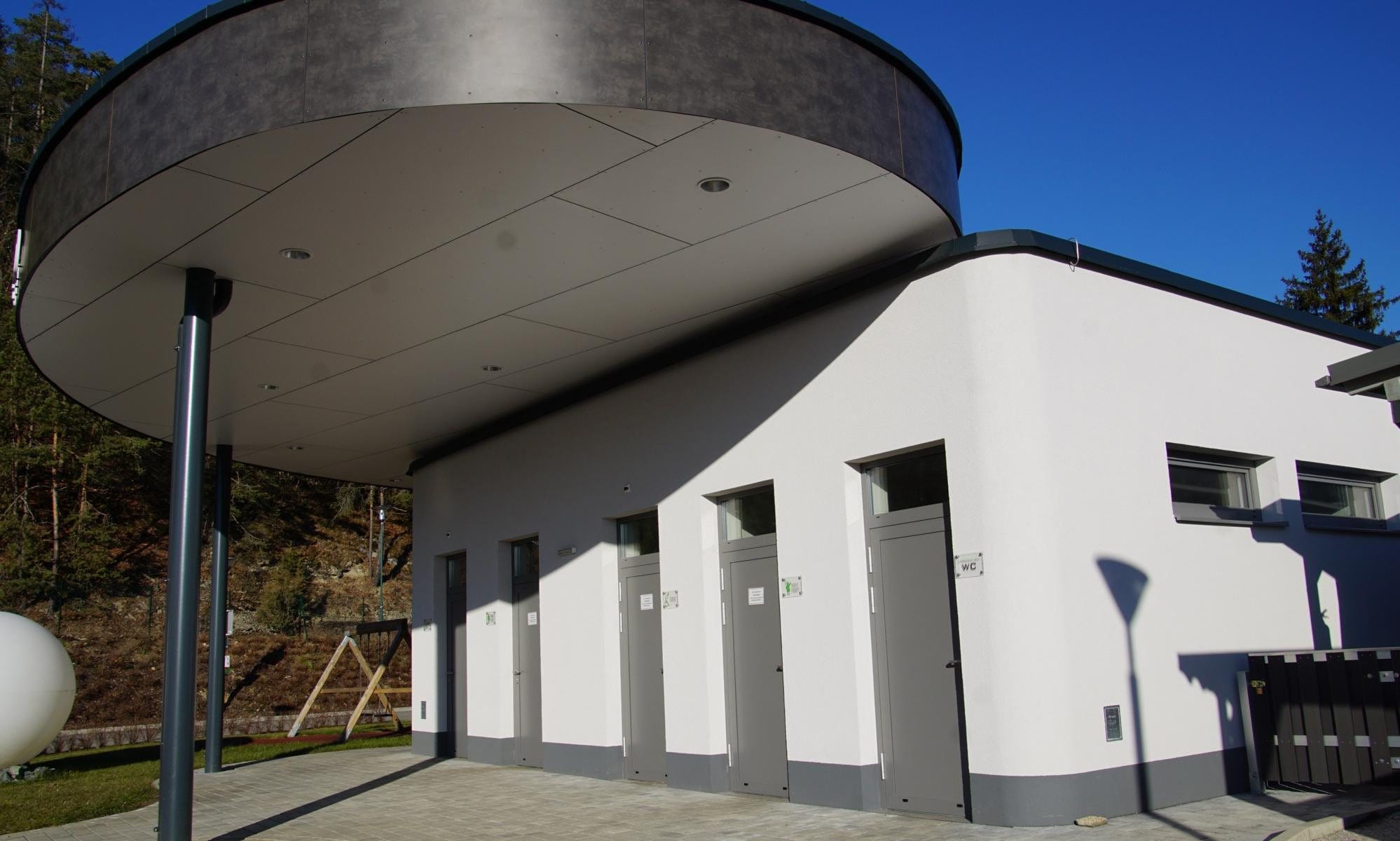 Modernes Sanitärgebäude mit überdachtem Eingangsbereich